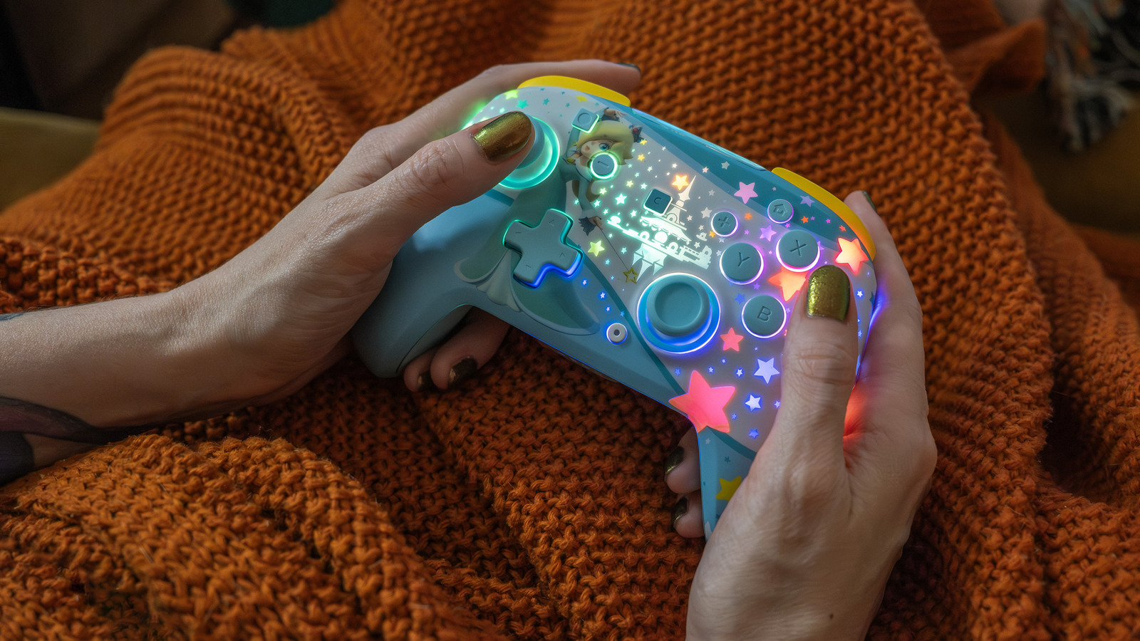 A Turtle Beach lançou o Rematch, um controle sem fio para o Switch 2 que une o charme licenciado da Nintendo a um hardware realmente sério. Tem edições da Mario, da Princesa Peach, da Rosalina e do KK Slider com efeitos de LED RGB, além de um modelo todo preto para quem curte um visual mais discreto.

O grande destaque são os analógicos TMR, ultra precisos e feitos para nunca dar drift - algo que nem o Switch 2 Pro Controller oficial oferece. Some uma bateria de 40 horas, controles de movimento, botões traseiros remapeáveis e uma tecla dedicada ao GameChat, e você tem um gamepad de baixa latência que se sai bem em Mario Kart World, Hello Kitty Island Adventure e Resident Evil Requiem.

Faltam o rumble e o despertar do console, e o corpo leve soa meio oco. Ainda assim, é a prova de que vale apoiar marcas que colocam criatividade e cuidado em primeiro lugar, em vez de espremer os fãs até o último centavo. Só a edição da Rosalina já justifica o espaço na estante.