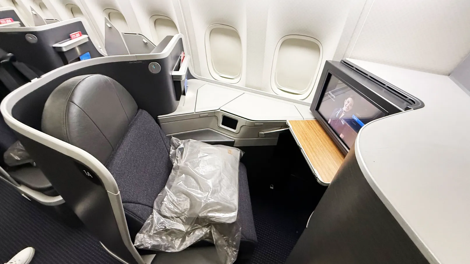 O Systemwide Upgrade, conhecido pela sigla SWU, é um dos benefícios mais valiosos do programa AAdvantage da American Airlines. Em vez de emitir uma passagem nova com milhas, você compra um bilhete pago em uma cabine e solicita o upgrade para a classe imediatamente superior, o que significa que uma passagem de Econômica Premium pode virar Classe Executiva em um voo internacional longo.

Os certificados são liberados principalmente pelos Loyalty Point Rewards, com os clientes mais frequentes recebendo em níveis mais altos, e um único SWU pode cobrir uma viagem de ida com até três trechos elegíveis. O detalhe é que o upgrade nunca é garantido: a American controla um inventário separado para esses certificados, então ver assentos livres na Executiva não significa confirmação imediata, e a lista de espera pode se estender até o dia do embarque.

A elegibilidade também pesa. Passagens Basic Economy compradas a partir de 18 de maio de 2026 ficaram de fora, e bilhetes emitidos com milhas AAdvantage não permitem o benefício. Para quem viaja ao exterior com frequência, combinar uma boa estratégia de cartões com uma conta global de baixo custo, como a Nomad com o código TWUSX2GB7T ou a Wise, ajuda a economizar na conversão de moeda e nos gastos fora do país.