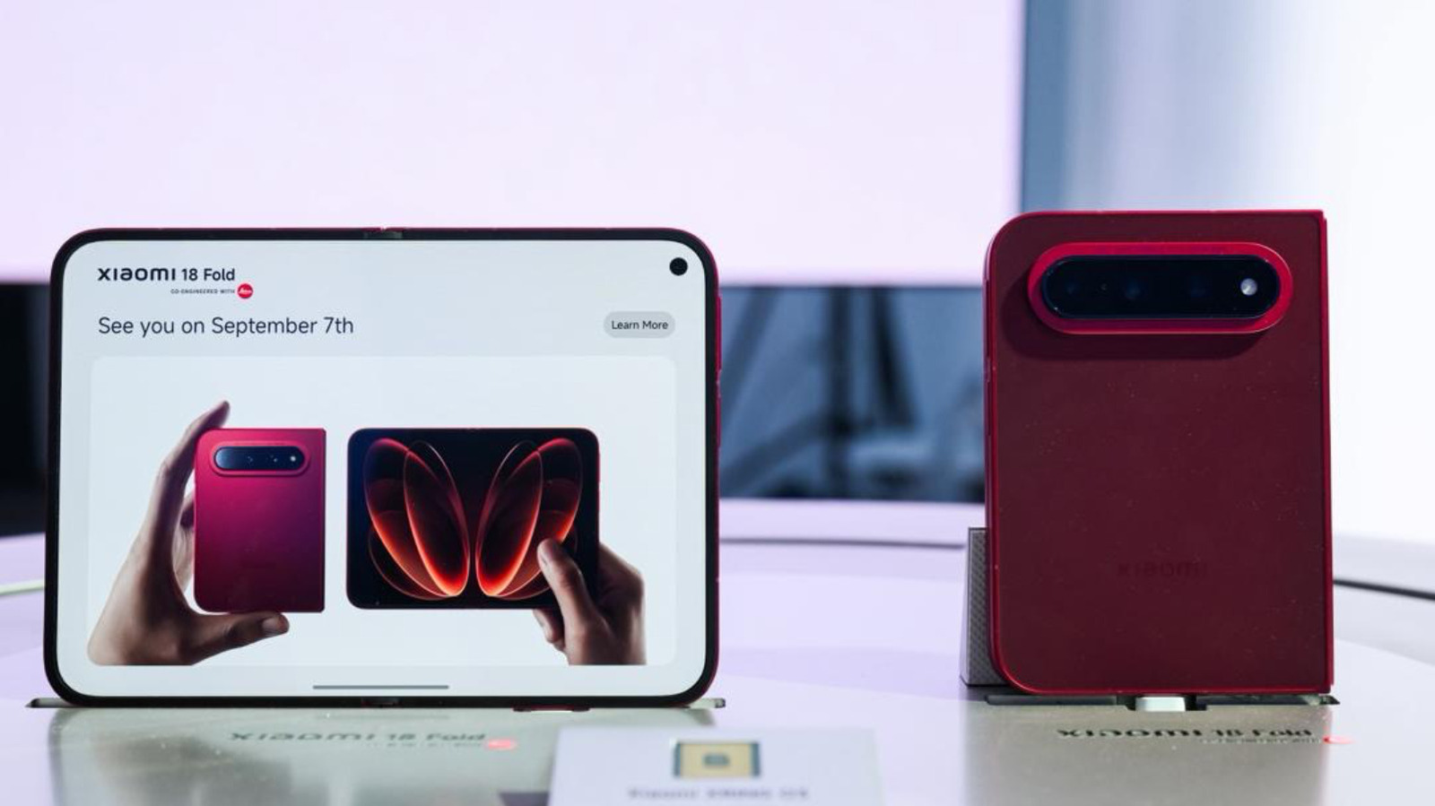 A Xiaomi roubou a atenção na IFA 2026 ao apresentar o Fold 18 Pro, um novo dobrável com formato mais largo e curto, parecido com um passaporte. A proposta chega para encarar o Galaxy Z Fold 8, e o acabamento em vermelho superesportivo deixa o visual ainda mais marcante. As especificações completas só saem em 7 de setembro, mas o produto já está provocando burburinho.

O aparelho também chama atenção por dentro: o SoC proprietário XRING 03, voltado para IA, deve unir CPU, GPU, NPU e chips de IA em uma única plataforma, possivelmente sem Snapdragon. A câmera com assinatura Leica reforça o apelo premium. O Fold 18 Pro promete ser um dos lançamentos mais comentados do ano.
