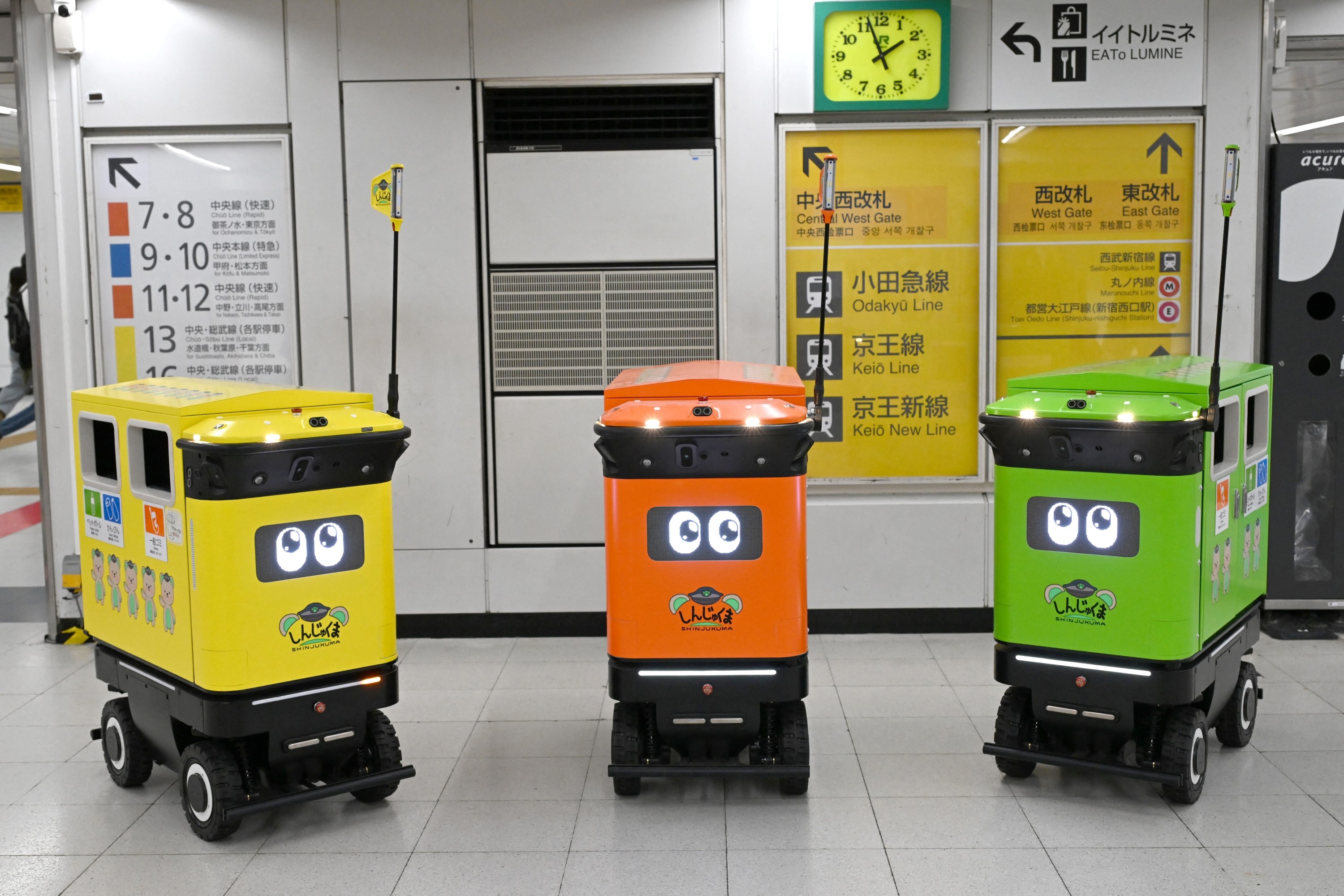 A estação de Shinjuku, recordista do Guinness como o maior hub ferroviário do planeta com mais de 2,7 milhões de passageiros por dia, virou campo de testes ao vivo para três robôs autônomos que circulam pelos corredores subterrâneos recolhendo lixo. Com pouco mais de um metro de altura, eles avançam a 20 centímetros por segundo, pegam os resíduos e os levam até os funcionários responsáveis pela remoção.

A operadora JR East anunciou que o teste vai até o fim de novembro e quer medir o quão seguro e confiável é automatizar uma tarefa pesada em um dos lugares mais caóticos do mundo. Na área que ela administra há apenas sete lixeiras para lixo comum e reciclável, e as equipes precisam esvaziá-las manualmente mais de dez vezes por dia, exatamente o tipo de trabalho repetitivo e desgastante que as máquinas estão sendo testadas para absorver.

É um retrato de como a robótica está entrando de vez na infraestrutura pública, assumindo as tarefas sujas e ingratas enquanto as pessoas ficam com o trabalho de maior valor. Se o piloto aguentar milhões de passos e o movimento constante, é questão de tempo até outras cidades copiarem o modelo.