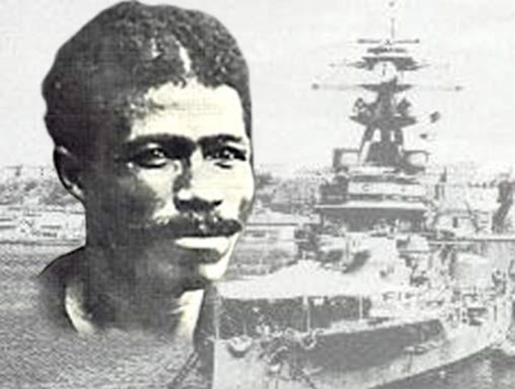 Em um giro histórico, a Justiça Federal condenou o Estado brasileiro pelas tentativas contínuas da Marinha de manchar a memória de João Cândido, o almirante negro que liderou a Revolta da Chibata. As decisões reconhecem que a linguagem institucional da Marinha cruzou a linha do racismo e da depreciação moral, violando valores constitucionais como dignidade humana, igualdade racial e direito à memória.

As sentenças representam uma grande vitória para a justiça reparatória. João Cândido foi perseguido por décadas após 1910 e, mesmo depois de receber anistia post mortem em 2008, sua família e seu legado seguiram sem reparação plena. Mais do que uma disputa jurídica, é um acerto de contas com o racismo institucional e uma exigência de que os heróis negros finalmente recebam o respeito que merecem.