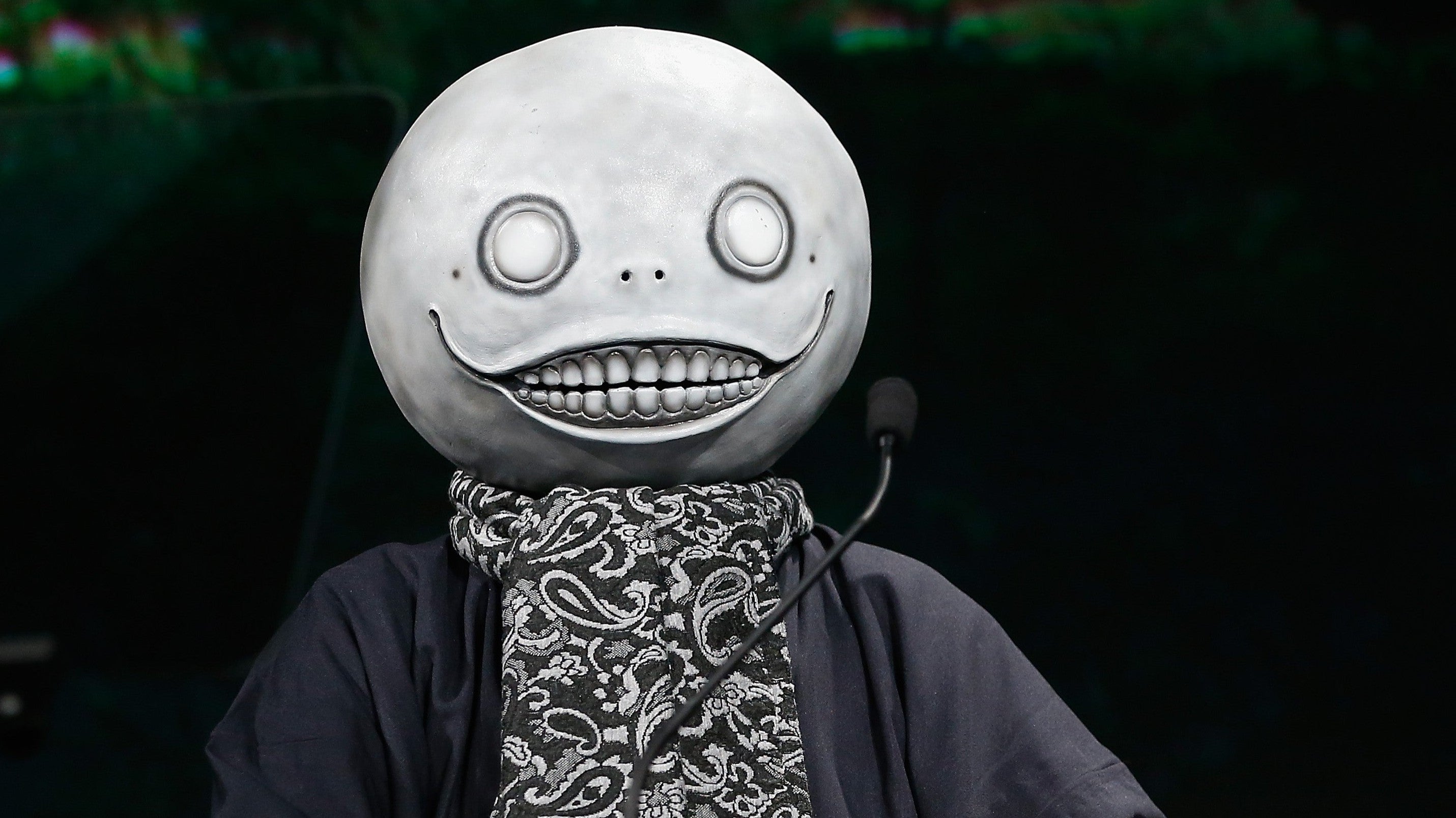 Yoko Taro acabou de fazer uma das confissões mais sinceras que a indústria dos games já ouviu. O criador de NieR e Drakengard diz que está cansado de trabalhar, que já realizou o sonho da vida logo no seu primeiro projeto como diretor e que tudo depois disso é apenas "o restante da minha vida".

Então por que continua? Dois motivos, e nenhum é glamouroso: ele ainda precisa da renda e tem pavor de desenvolver demência na velhice, medo que ele diz driblar repetindo a si mesmo que cada dia difícil no trabalho ajuda a prevenir o problema. Pense nisso, um dos autores mais influentes dos games está atravessando dias ruins por medo, não por paixão, um retrato brutal do que uma indústria movida por contratos instáveis e cancelamentos constantes faz com quem cria a sua arte.

Taro também olhou para o futuro, celebrando como a IA e as novas ferramentas permitem que criadores na casa dos 15 a 20 e poucos anos façam jogos sem implorar por autorização de uma publisher, ao mesmo tempo em que avisa que essa liberdade vai espalhar a concorrência como fogo entre gerações. Aos 56 anos, ele diz que só torce para as chamas não o alcançarem antes de partir, e revela que vários projetos recentes foram silenciosamente cancelados no meio do desenvolvimento enquanto os fãs achavam que ele não estava fazendo nada.