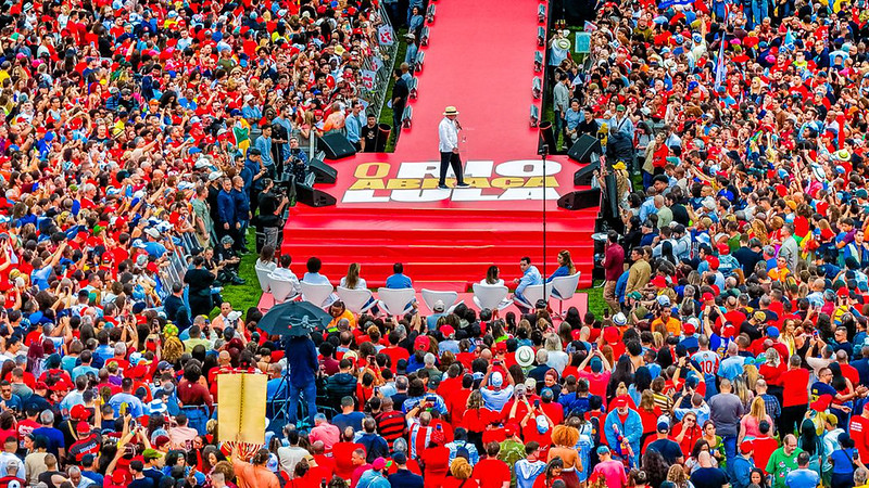 A campanha presidencial de 2026 no Brasil está pegando fogo. Lula abriu sua agenda no Rio com um grande comício em Bangu, prometendo escolas em tempo integral, novos institutos federais e uma política de segurança baseada em inteligência e prisões estruturadas, e não em confrontos e mortes.

Enquanto isso, o candidato da extrema direita, Flávio Bolsonaro, radicalizou o discurso no Maracanãzinho ao propor tratar facções e milícias como organizações terroristas, reduzir a maioridade penal para 14 anos em casos de estupro e adotar castração química para condenados por crimes sexuais. O contraste é nítido: de um lado, investimento social e fortalecimento democrático; do outro, um pacote autoritário de punição.

Com todos os candidatos nas ruas, a eleição se desenha como uma disputa decisiva pelo futuro do país.