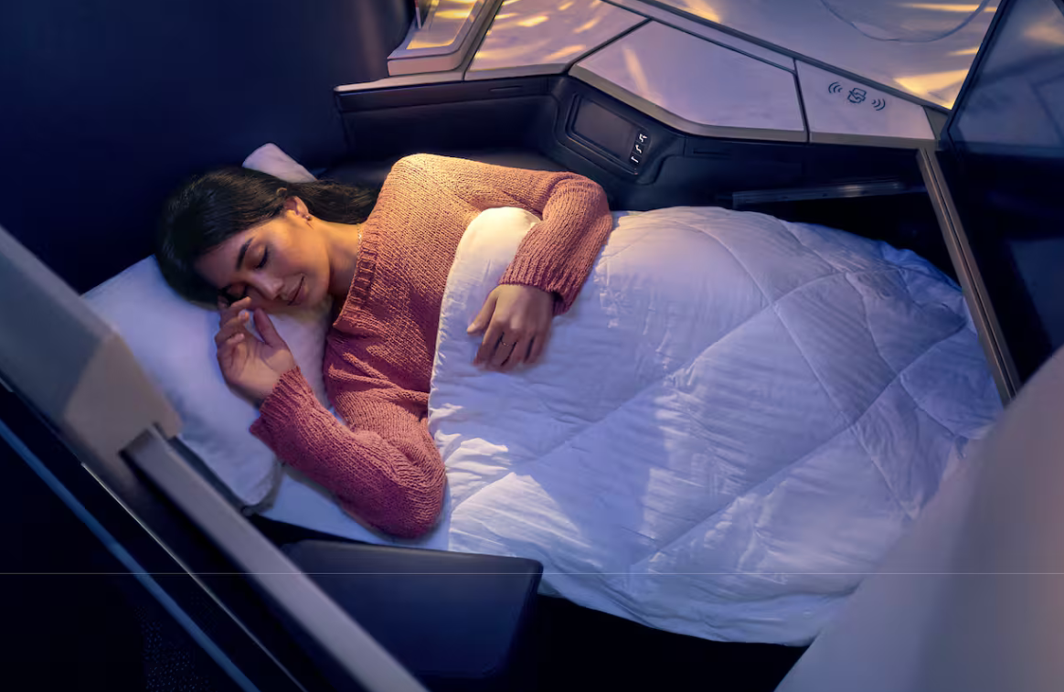 A Etihad Airways acaba de apresentar o Etihad Wellbeing, um programa criado para transformar o voo em algo muito além de uma prova de resistência. A proposta é ambiciosa: manter o passageiro saudável, descansado e lúcido do lounge até o desembarque, começando por espaços tranquilos e tratamentos de spa no Aeroporto Internacional Zayed e seguindo para uma cabine pensada para a recuperação.

A bordo, os detalhes pesam. Na Primeira Classe e em The Residence, os passageiros encontram roupa de cama de algodão natural, colchões de espuma viscoelástica, pijamas premium e produtos ESPA, enquanto a Classe Executiva ganha os novos kits Destination Collection com máscaras noturnas e creme para as mãos da LANEIGE. A iniciativa Quiet Cabin reduz anúncios desnecessários, e conteúdo de meditação, alongamento e sono, somado à iluminação que combate o jet lag, ajuda a chegar renovado.

A gastronomia segue a mesma lógica, com pratos ricos em proteínas e foco em vegetais, além de opções sem glúten, com baixo teor de sódio e de gordura, acompanhadas de bebidas com vitaminas e eletrólitos. Uma fragrância exclusiva de cabine fecha a experiência. É um recado claro: a disputa pela fidelidade nas rotas longas agora se decide na qualidade do sono, na hidratação e em como você se sente ao sair do avião.