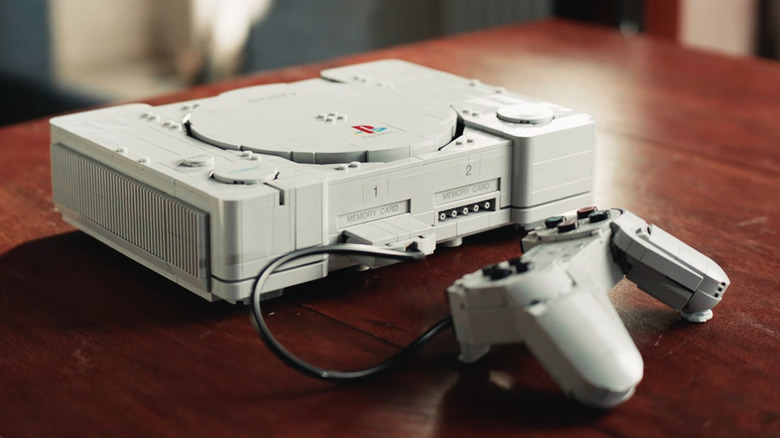 Prepare para montar um pedaço da história dos games. Durante a State of Play de hoje, a Lego confirmou uma réplica quase 1:1 do PlayStation original de 1995, que será lançada em 1º de outubro. O set tem 1.911 peças, cerca de 10,5 polegadas de largura, controle detalhado com botões mecânicos e dioramas escondidos de Ape Escape e Gran Turismo.

A cena de Ape Escape traz uma ilha com o rosto do macaco mais famoso do game, e você pode escolher entre luz vermelha ou azul no capacete. Já o diorama de Gran Turismo inclui uma pista pequena e carrinhos minúsculos. Para quem cresceu com o console cinza que mudou os videogames, é mais uma homenagem do que um simples brinquedo.

O preço é US$ 180 e a chegada está marcada para outubro. Sem microtransações, sem serviços ao vivo: só a alegria de construir um dos consoles mais icônicos da história em blocos de montar.